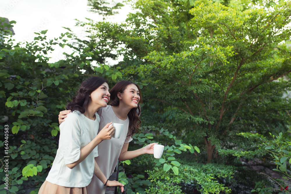 Happy young women friends well-dressed smiling while standing together Happy young women friends well-dressed smiling while standing together