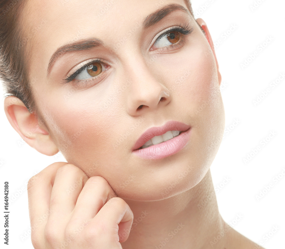 Closeup view of beautiful young woman with natural lips makeup touching face on white background Closeup view of beautiful young woman with natural lips makeup touching face on white background