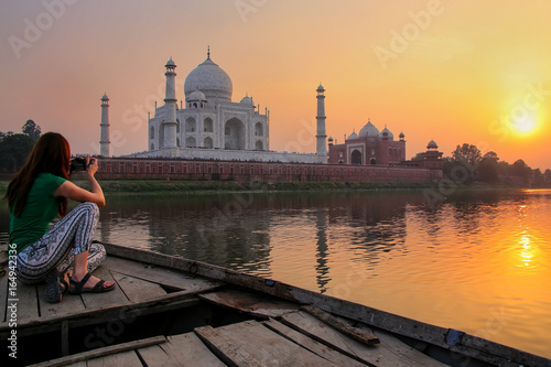 Canvas Print Woman watching sunset over Taj Mahal from a boat, Agra, India