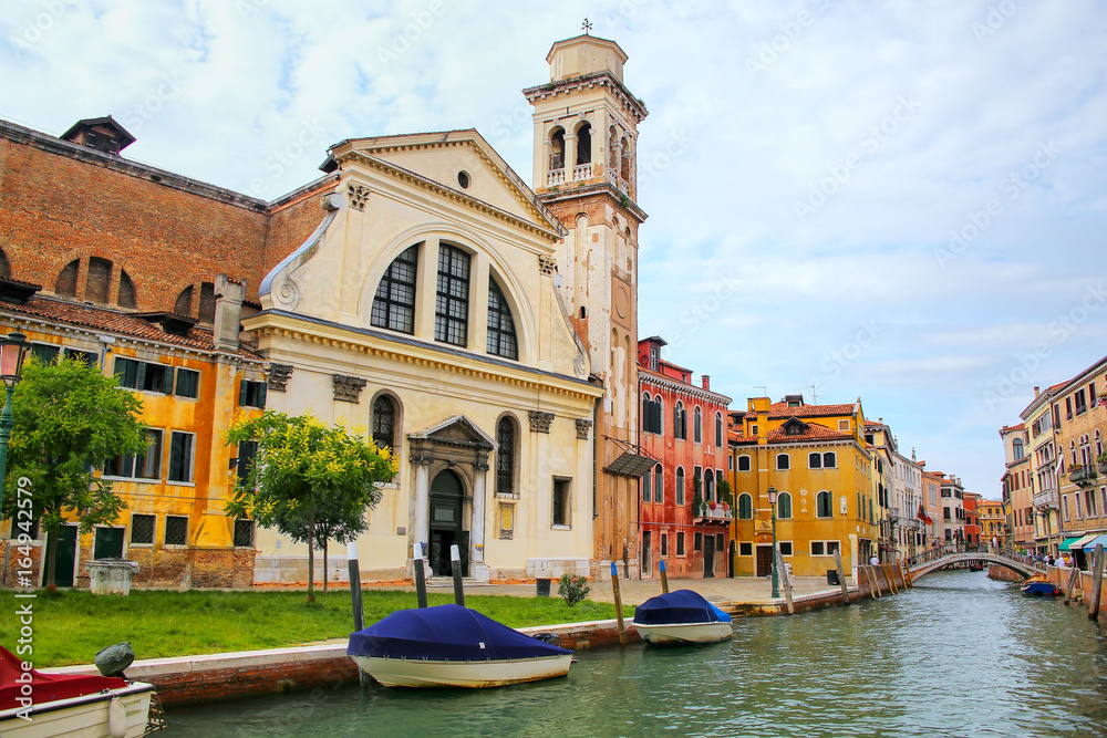 Old church and houses on a narrow canal in Venice, Italy.