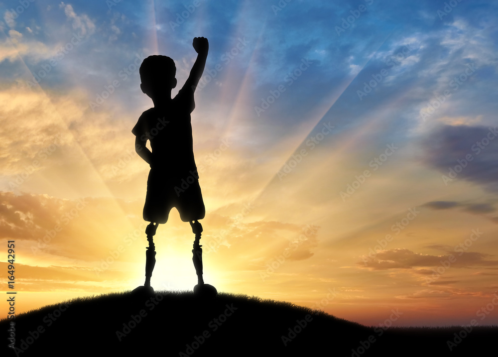Happy disabled boy with a prosthetic leg standing on top Happy disabled boy with a prosthetic leg standing on top