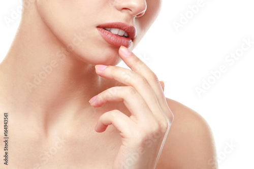 Woman with natural makeup touching lips on white background