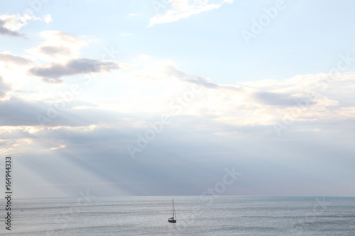 yacht in the sea rays from clouds landscape photo
