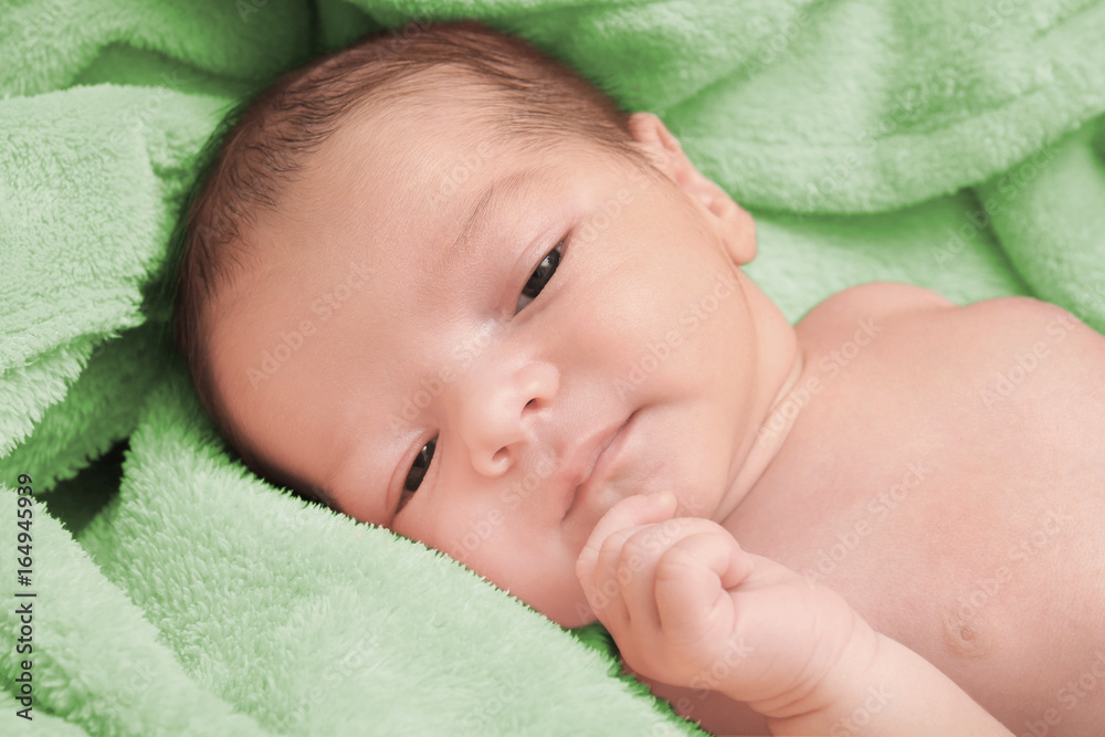 Cute newborn baby boy lying on soft plaid at home Cute newborn baby boy lying on soft plaid at home