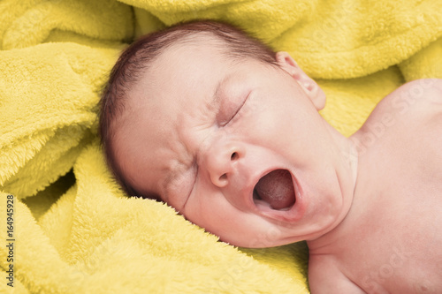 Yawning newborn baby boy on...