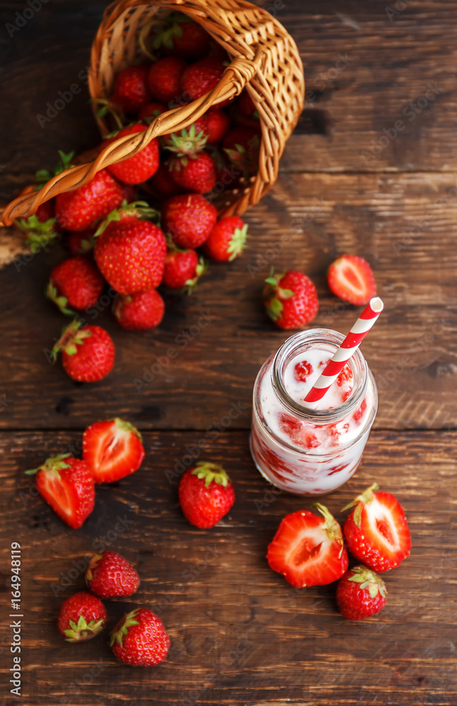 Strawberry smoothie or milkshake in jar and basket on old rustic background