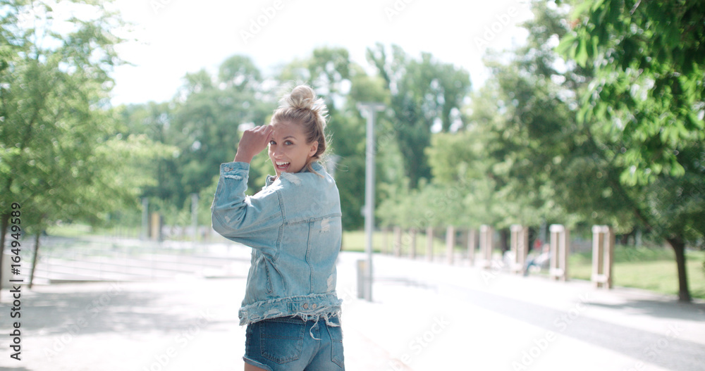 Happy stylish girl wearing denim jacket enjoying time during sunny day in a park. Happy stylish girl wearing denim jacket enjoying time during sunny day in a park.