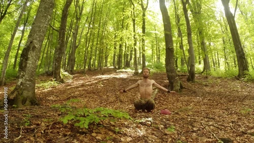 the Man is Squatting and Waving His Arms in Broad Sweeps in the Old High Green Sunny Forest the General Plan