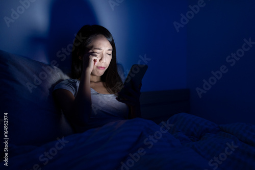 Woman feeling eye pain with using cellphone at night