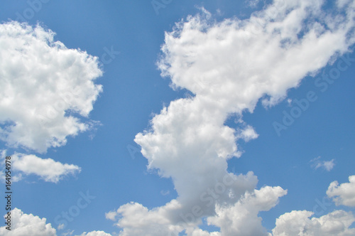 Background with a blue sky and white clouds. White fluffy clouds in the blue sky  