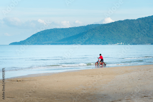 kid boy driving bicycle in the beach