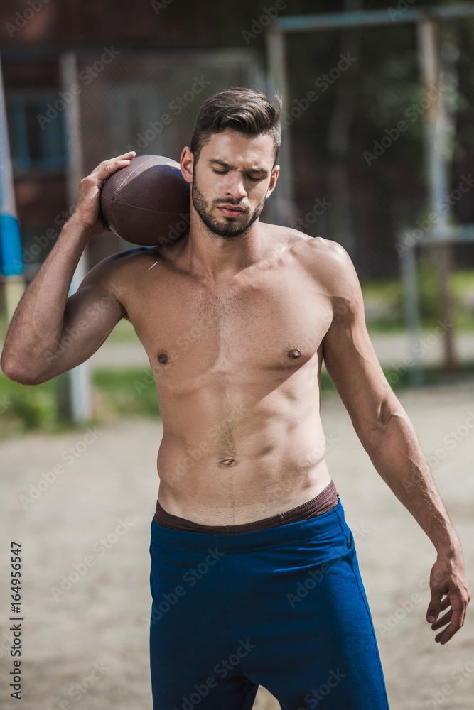 young handsome male football player with ball on court young handsome male football player with ball on court