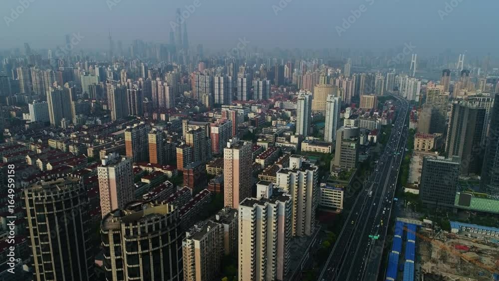Aerial view on Shanghai with urban residential buildings, elevated road and the financial district in the background Aerial view on Shanghai with urban residential buildings, elevated road and the financial district in the background