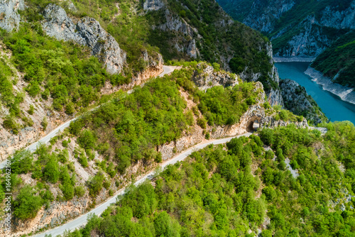 Top view of mountains covered with green forest with highways