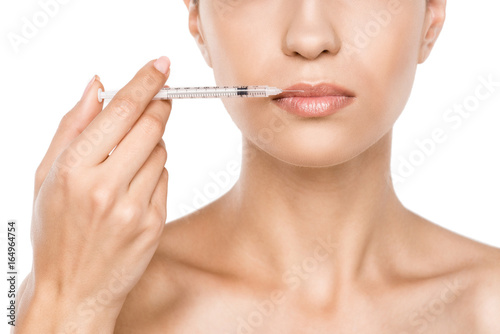 cropped view of beautiful woman making beauty injection for lips, isolated on white