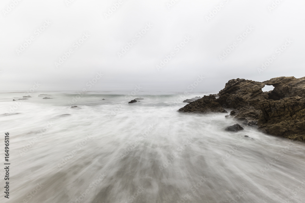 Obraz premium Rocky Leo Carrillo State Beach with motion blur water in Malibu, California.