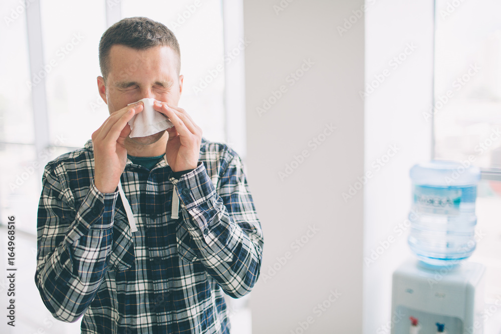 picture from a young man with handkerchief. Sick guy has runny nose. makes cure for the common cold picture from a young man with handkerchief. Sick guy has runny nose. makes cure for the common cold