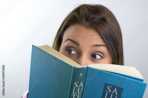 Ragazza nascosta dietro a un libro photo