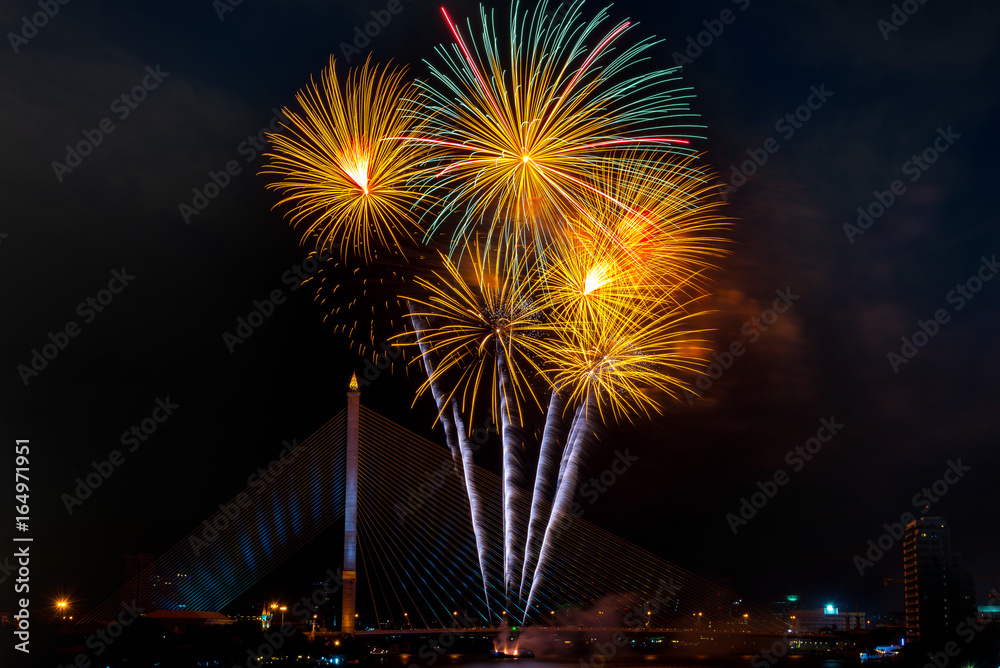 Beautiful yellow and green color firework display for celebration happy new year and merry christmas in the night sky, bangkok city, thailand