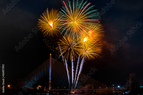 Beautiful yellow and green color firework display for celebration happy new year and merry christmas in the night sky, bangkok city, thailand © lukyeee_nuttawut