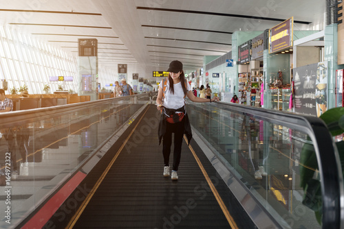 traveller woman on travelator at international airport.