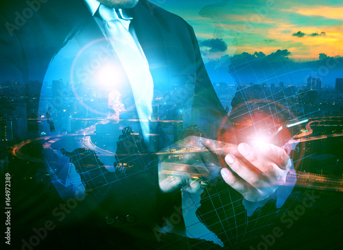 multi exposure business man touching on mobile phone screen with world map and modern city life background