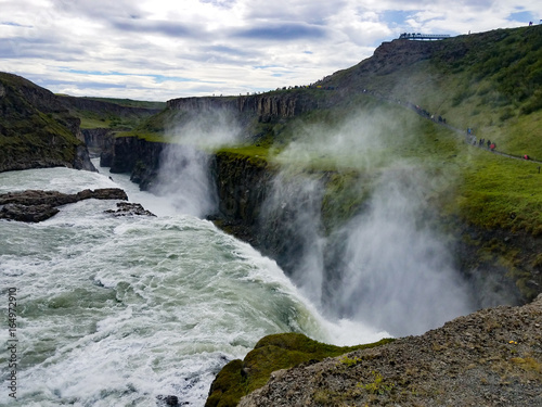 Icelandic waterfall with green surrounding fields