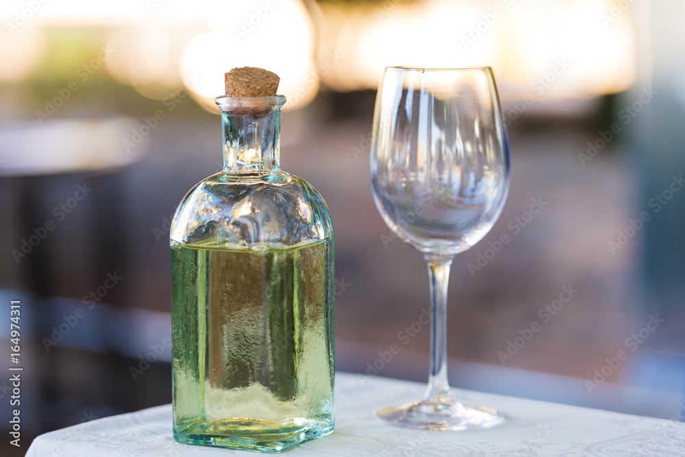 A bottle of water and a wineglass on the table. Close-up. A bottle of water and a wineglass on the table. Close-up.