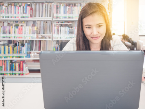 Beautiful student using laptop in library