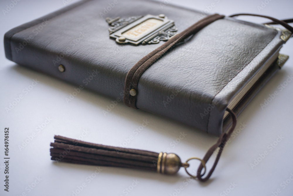 Brown leather handmade scrapbooking notebook for travellers scraps and memories, made as a gift, with tassel, corners and lace as decoration Brown leather handmade scrapbooking notebook for travellers scraps and memories, made as a gift, with tassel, corners and lace as decoration