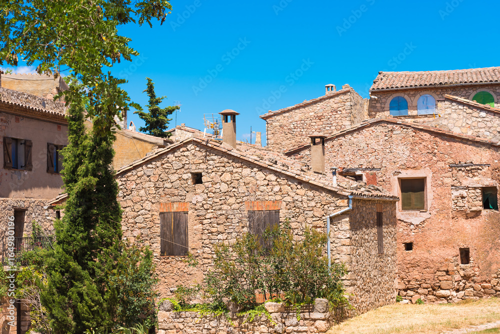 View of the buildings in the village Siurana de Prades, Tarragona, Catalunya, Spain. Isolated on blue background.