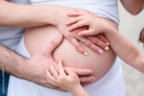 Wallpaper Mural The hands of a father and daughter on the belly of a pregnant mother. Torontodigital.ca