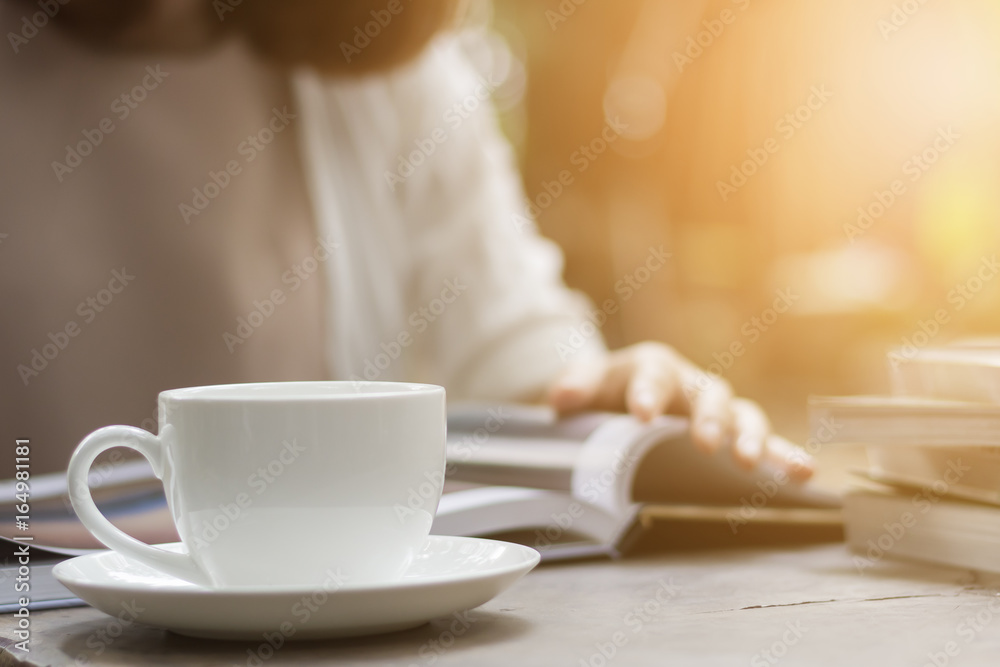 Woman is reading a book and drinking coffee in the garden. Woman is reading a book and drinking coffee in the garden.