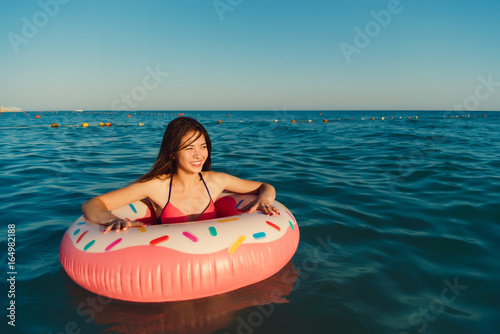 Beautiful woman in an inflatable floating ring in the form of a donut