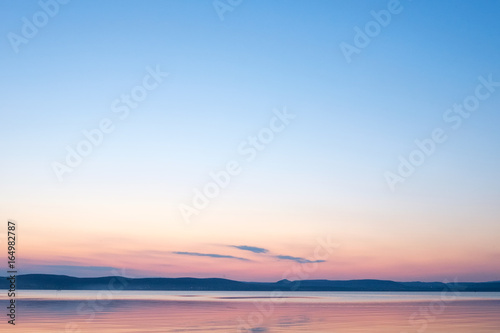 soft and calm sunset at Balaton lake in summer - thin clouds, velvet sky and hills in background © peter gueth