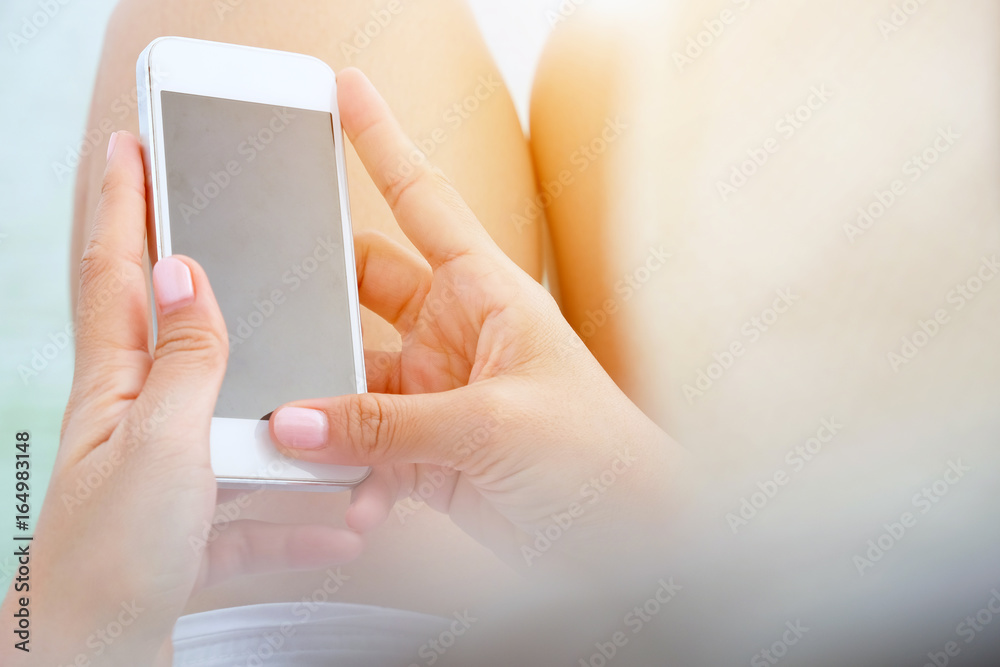 Close-up of female hands using smart phone with flare light background. Searching Internet ,Social Networking Concept Close-up of female hands using smart phone with flare light background. Searching Internet ,Social Networking Concept