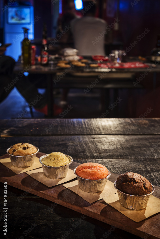 mixed freshly baked muffins in cozy coffeeshop interior