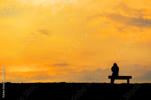 silhouette of woman relax on chair happy time sunset © thechatat