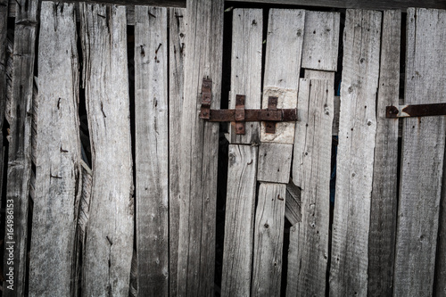 Rusty hasp on the doors of an old wooden shed, grunge style