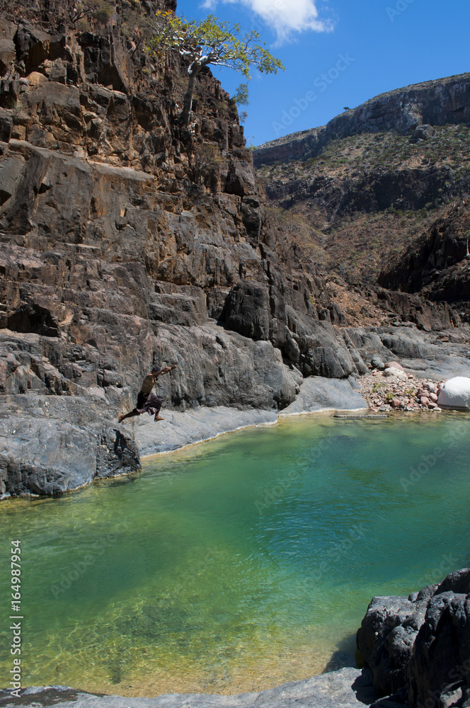 Yemen: ragazzi si tuffano e nuotano nel lago di montagna, il wadi, a Dirhur, nella foresta degli alberi di drago tra le montagne del Dixam Plateau sull'isola di Socotra