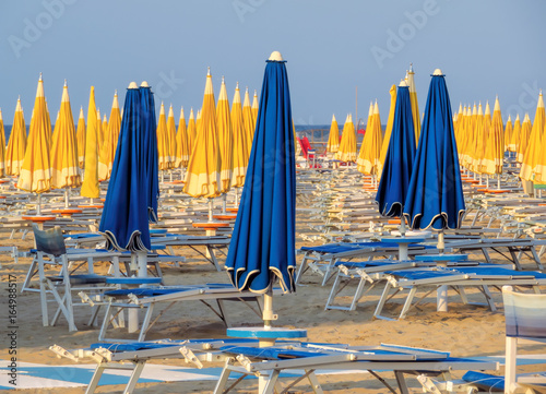 Rimini - Blue and yellow umbrellas and sunbeds photo
