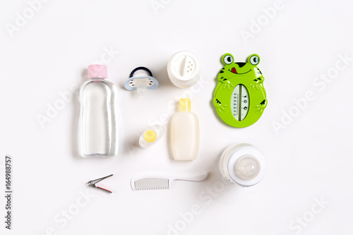 Hairbrush and cosmetics for newborns on a white background. Top view