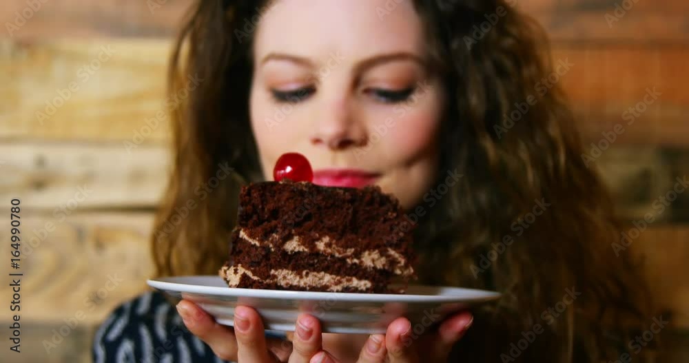 Portrait of female customer holding plate with pastry Portrait of female customer holding plate with pastry