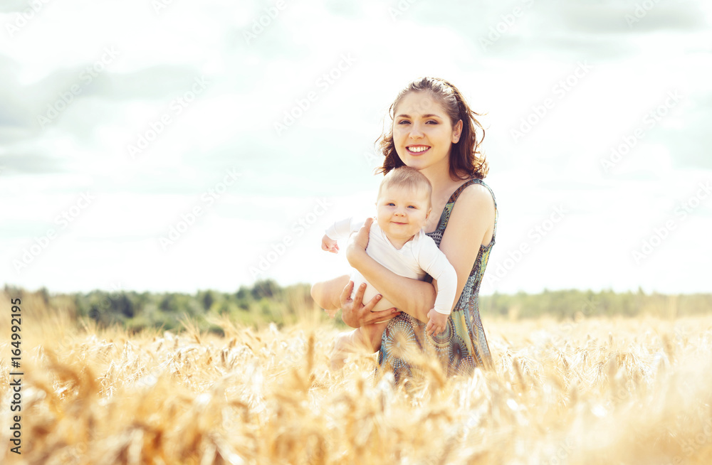 Beautiful woman holding baby. Mother and son walking in a meadow at summer. Beautiful woman holding baby. Mother and son walking in a meadow at summer.