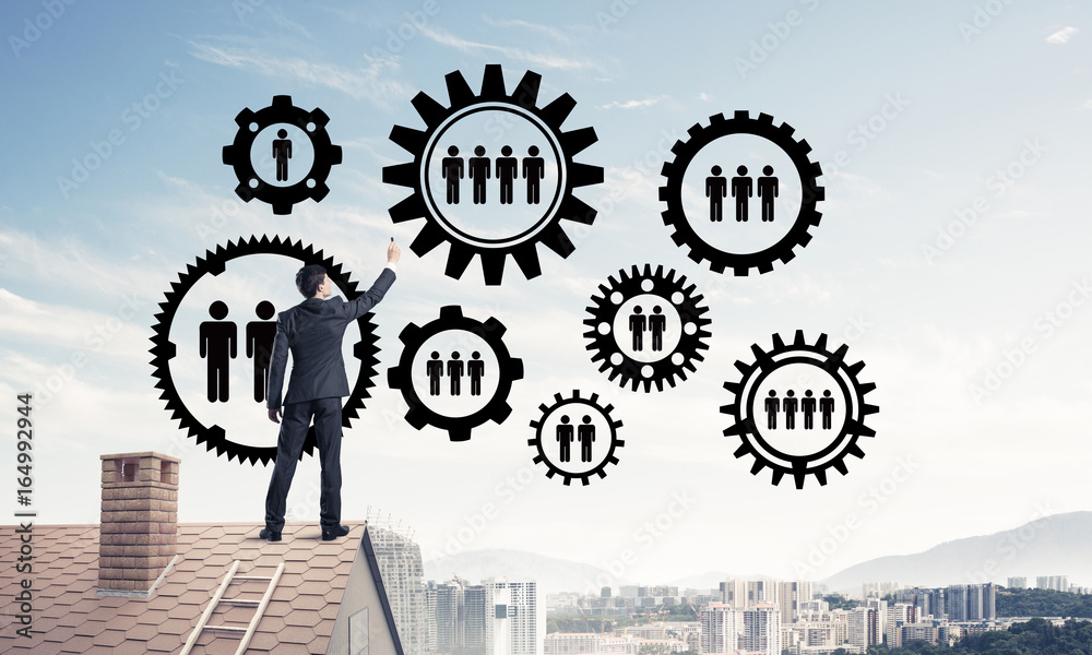 Businessman on house roof presenting teamwork and connection con Businessman on house roof presenting teamwork and connection con