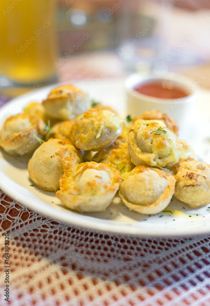 Traditional Russian pelmeni with cheese and tomato sauce.