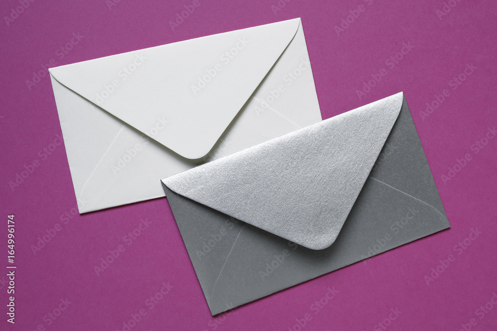 white and silver envelopes on pink background white and silver envelopes on pink background
