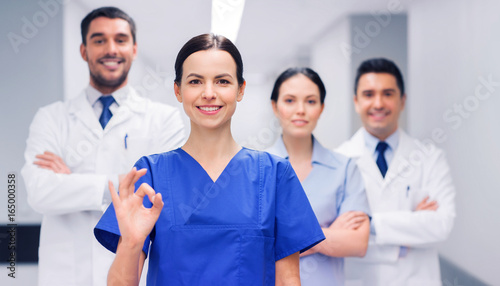 group of medics at hospital showing ok hand sign