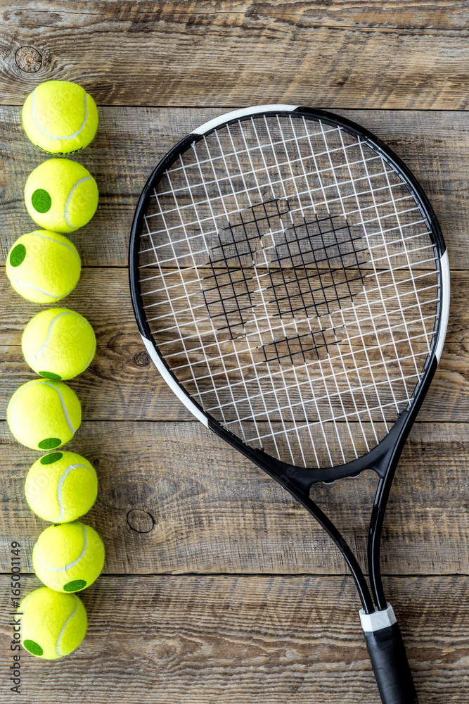 Sport gear. Tennis balls and racket on wooden background top view