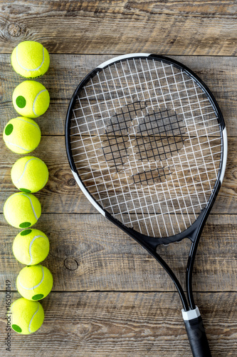 Sport gear. Tennis balls and racket on wooden background top view © 9dreamstudio